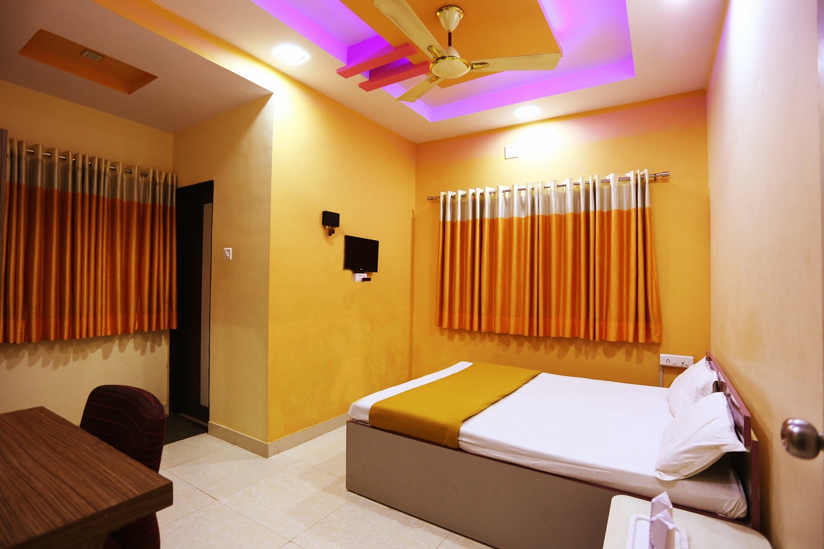 Close-up view of the cozy double bed in Hotel Somnath Sagar's air-conditioned room, highlighting clean linens.