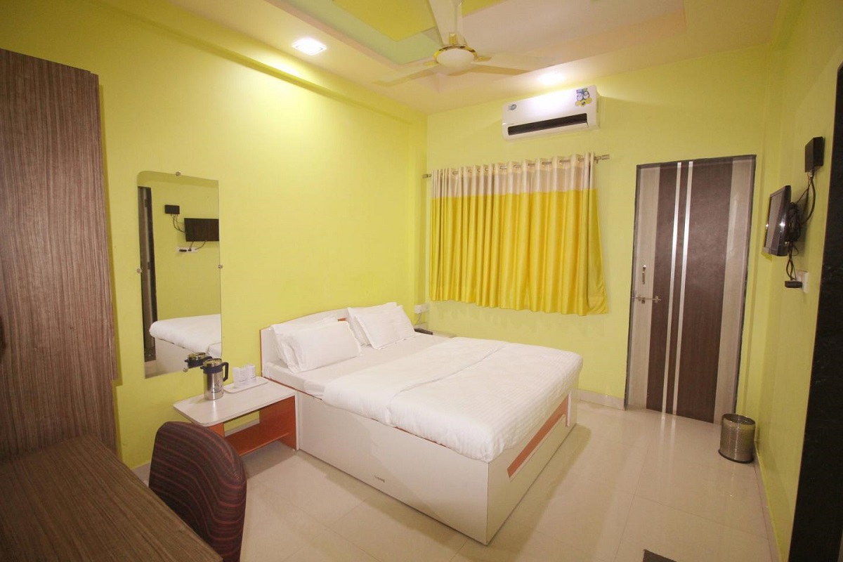 Bright double AC room at Hotel Somnath Sagar with a window offering natural light and a pleasant view.