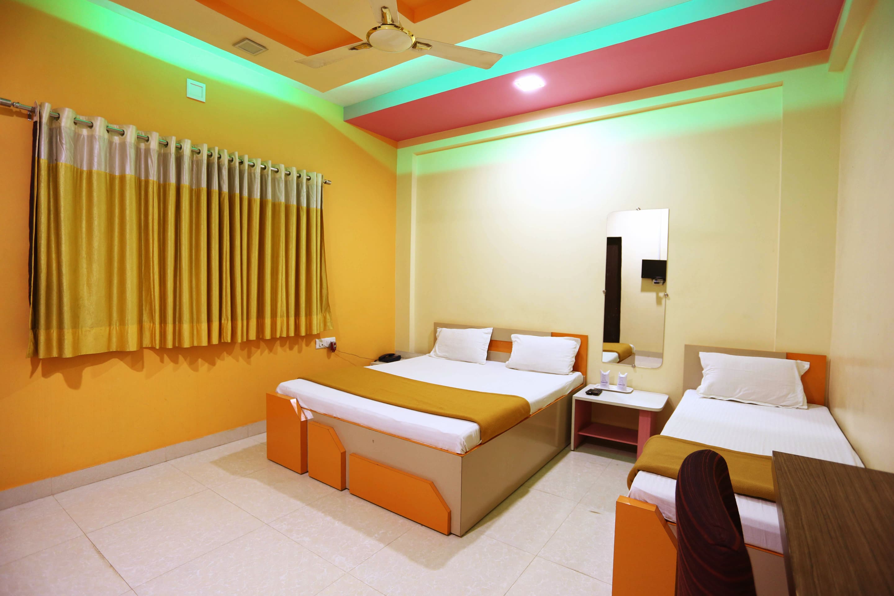 Well-lit and airy triple bed room at Hotel Somnath Sagar, Veraval, creating a relaxing stay for guests.
