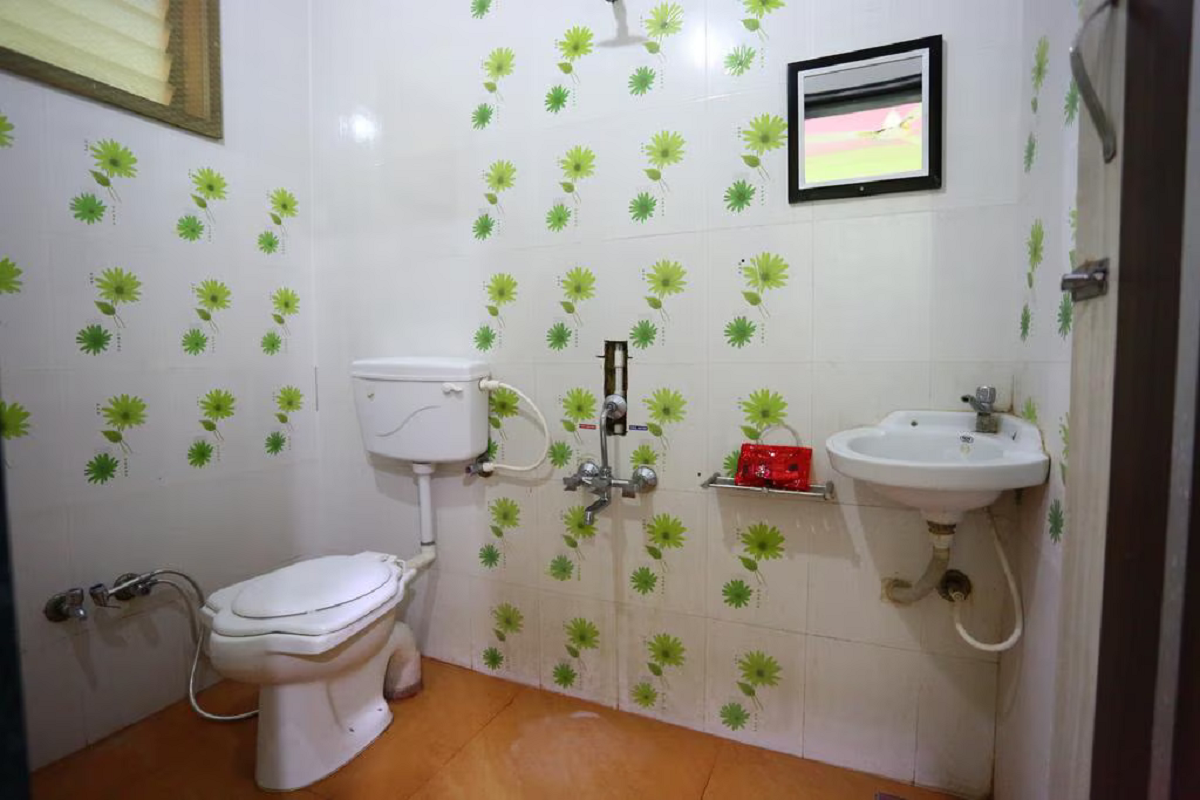 Hygienic and well-maintained private washroom in Hotel Somnath Sagar's triple room, with essential fittings for guest comfort.