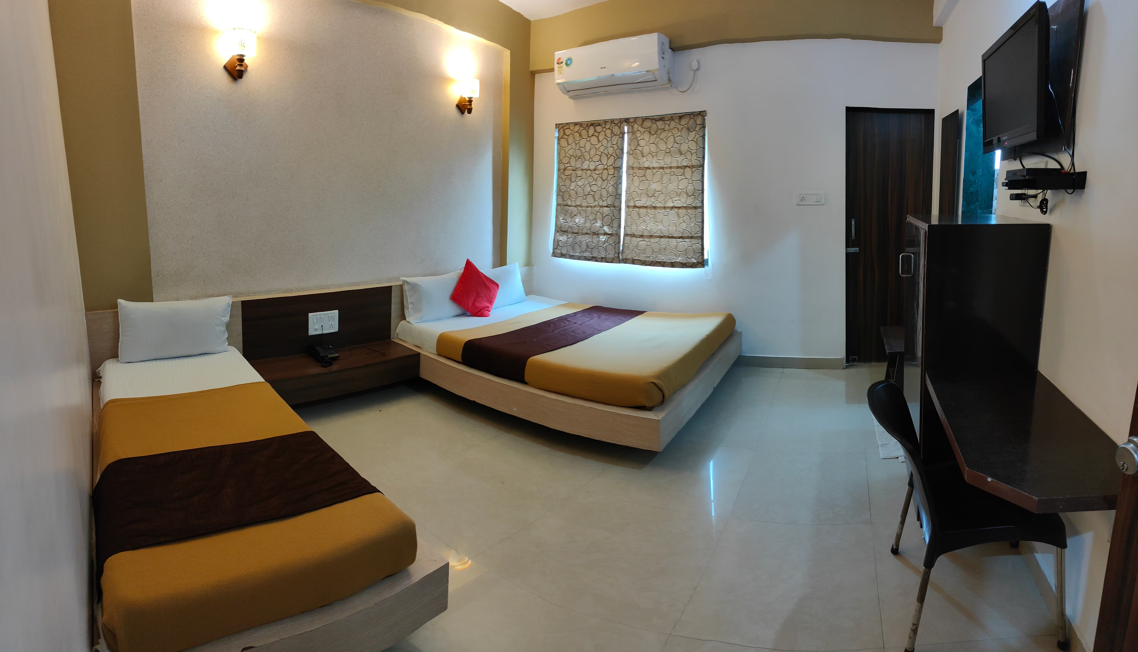 Comfortable layout of the Four Bed Room at Hotel Somnath Atithigruh, designed for a relaxing group stay.