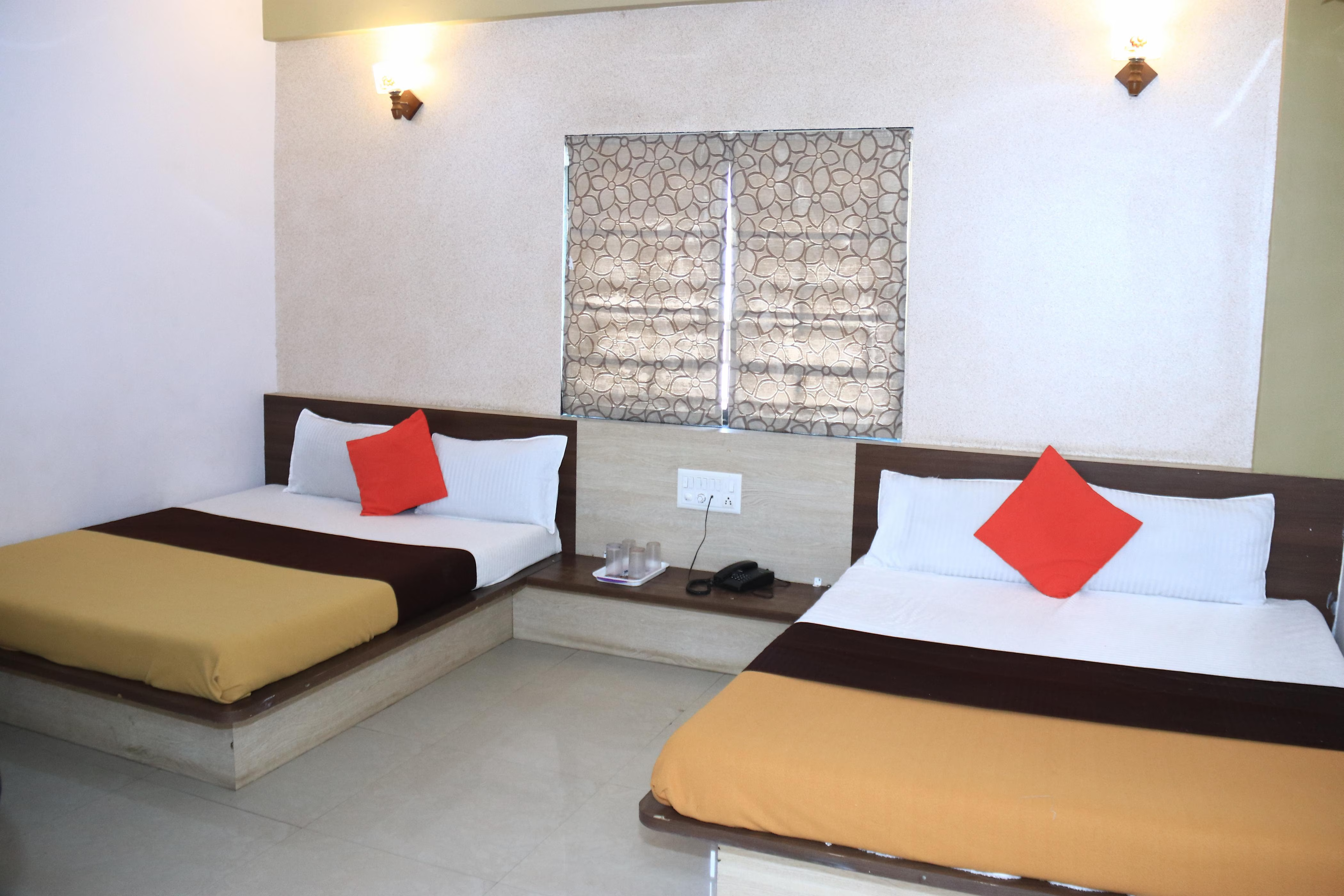 Interior perspective of Hotel Somnath Atithigruh's Four Bed Room, highlighting its ample space and bed configuration.